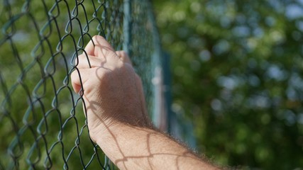 Fototapeta na wymiar Image with Man Hands on a Metallic Fence