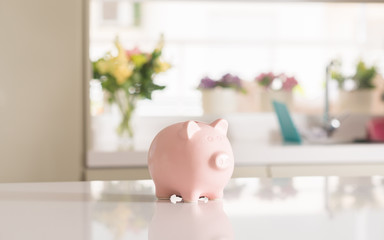 Piggy bank on table against beautiful natural indoor background