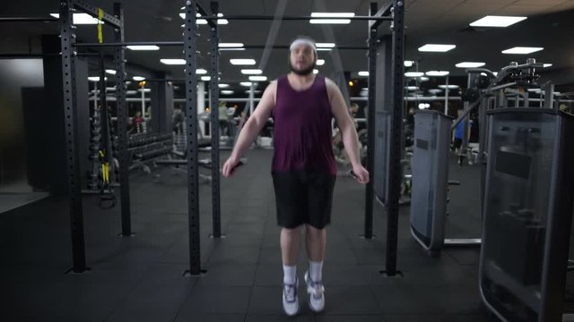 Fat man jumping rope, actively going in for sports to lose weight and get fit