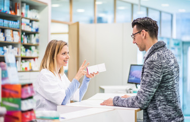 Female pharmacist serving a male customer.