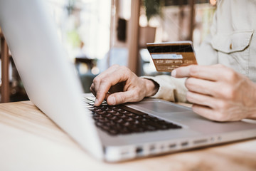 Man holding credit card and using laptop. Online shopping, business and technology concept