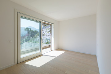 Empty white room with large window with a view.