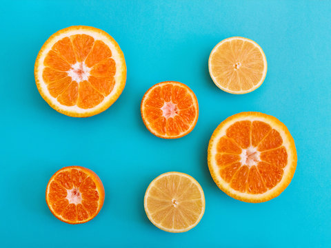 Citrus fruit Flat lay Halves of orange, lemon and mandarin are lying on bright blue background Photo template in top view
