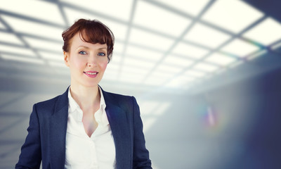 Smiling businesswoman against white room with windows at ceiling