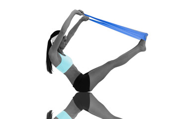 Fit young woman exercising with a blue yoga belt against mirror