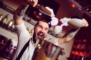 cheerful barman smiles, screams and falls asleep in a bucket for champagne on the background of the...