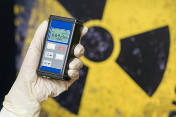 Radiation supervisor in glove with geiger counter checks the level of radiation