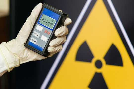 Radiation supervisor in glove with geiger counter checks the level of radiation
