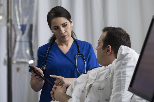 Physician using an ipad/tablet to give instructions to hospital patient