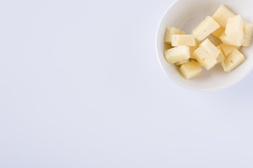 white bowl in a squere with pieces of tasty pecorino cheese on white background