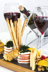 Cheese plate: roquefort with blue mold, cheddar, smoked cheese, mozzarella on a wooden board. Decorated with red currant berries, strawberries and mint