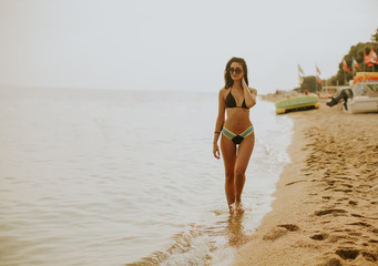 Fit and sporty woman in a swimsuit relaxing on a beach at summer