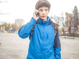 close up portrait of young male teenager speaking by his mobile phone