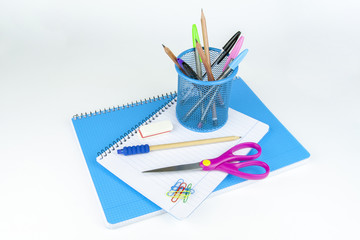 School accessories with pens, pencils, notebook, rubber, clips, scissors and pencil beaker