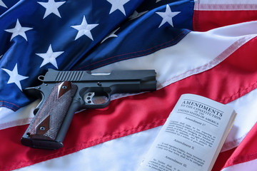 The second amendment and gun control in the US, concept. A handgun and the american constitution on...