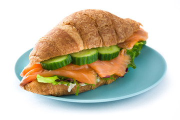 Croissant sandwich with salmon and vegetables isolated on white background