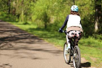 Young woman riding bicycle on path.