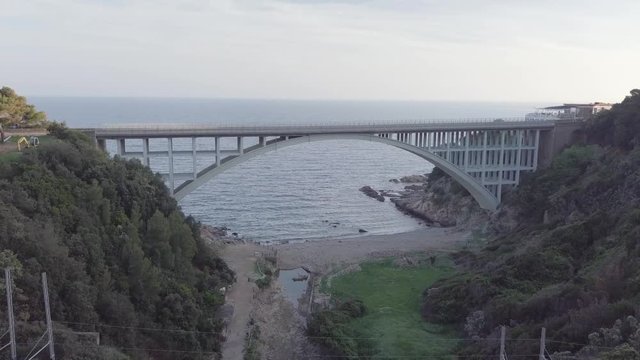 Ponte ad arco stradale in riva al mare. Vista aerea con drone.
