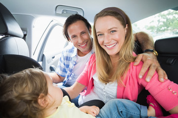 Fototapeta na wymiar Parents securing baby in the car seat