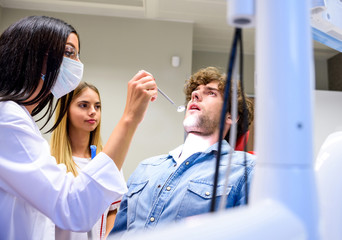 A female Dentist preparing to examine a Patient	