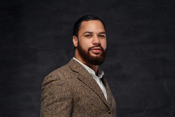 Fototapeta premium Handsome bearded African-American businessman in a brown classic jacket.