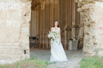Fototapeta premium Romantic beautiful bride in luxury dress posing of beautiful architecture