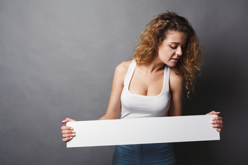 Young woman holding blank white banner