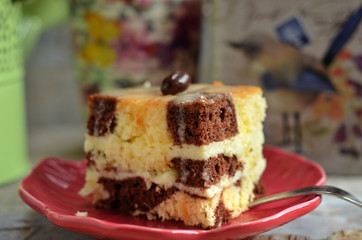 A piece of square cake on red plate