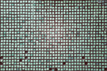 Green mosaic of square tiles for facing the building.