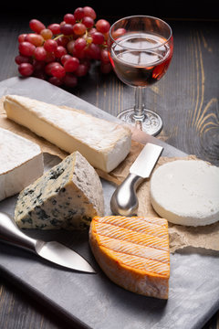French cheeses plate in assortment, blue cheese, brie, munster, soft goat cheese, Neufchatel heart shaped cheese