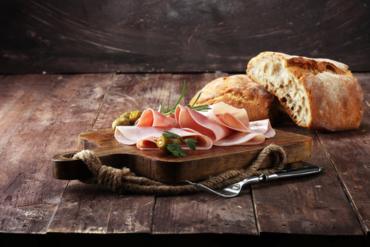 Sliced ham on wooden background. Fresh prosciutto. Pork ham sliced