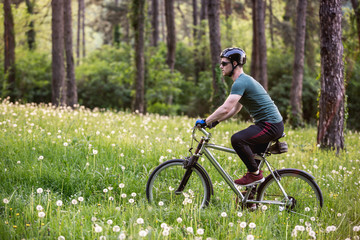 Fototapeta na wymiar Young man drive his bike in nature in deep grass