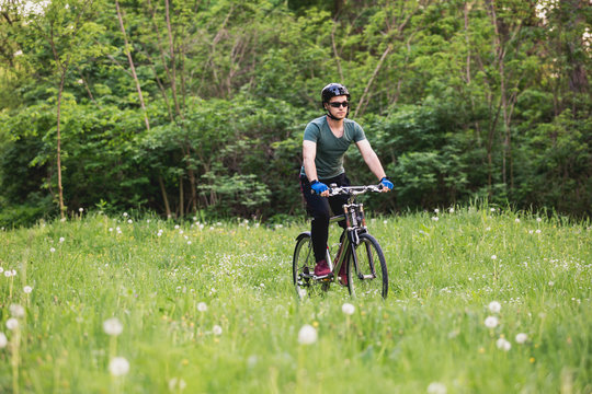 Young man drive his bike in nature in deep grass