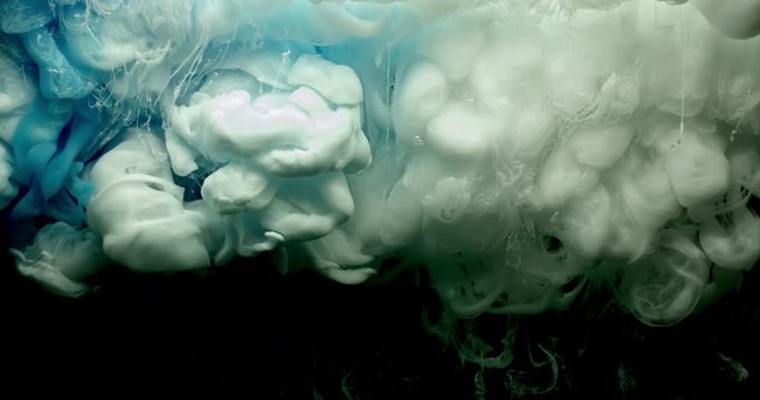 Blue and white ink spraying in water on black background shooting with 4k high speed camera.