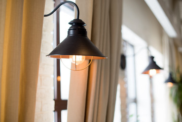 a lamp on the background of a window and a wall with curtains