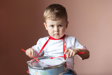Little boy playing the drum. Child development concept.