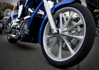 Detailed view of motorbike front wheel with disc break and tire.