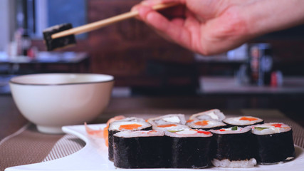 Sushi bar or restaurant, fresh sushi, Philadelphia cheese, crab sticks, salmon, rice, ginger, soy, macro.