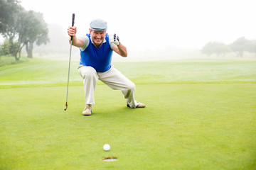 Obraz premium Happy golfer cheering on putting green