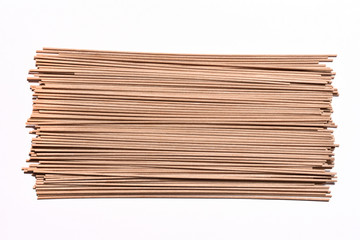 Beautiful buckwheat noodles, raw, not cooked, on white background