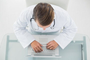Fototapeta na wymiar Overhead view of a male doctor using laptop