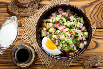 Traditional summer Russian cold soup with kvass, okroshka with ham and vegetables