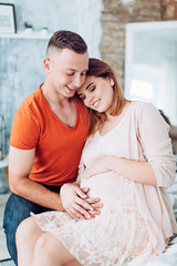 Beautiful pregnant woman and her husband is in their bedroom