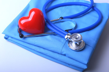 Doctor coat with medical stethoscope and red heart on the desk
