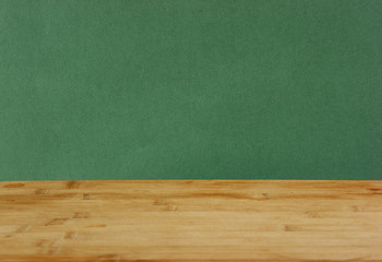 Old wooden deck table with green grunge background