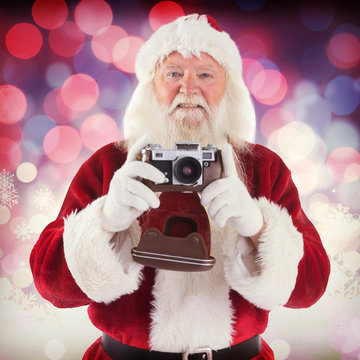 Santa is taking a picture against glowing christmas background