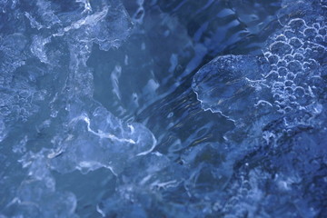 spring ice stream in the forest flows through the ice texture ice