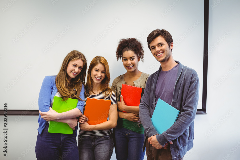 Poster students standing and smiling at camera holding notepads