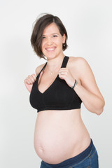 A pregnant woman in fitness clothes pregnancy belly on white background