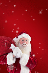 Santa Claus measures his belly against red snowflake background